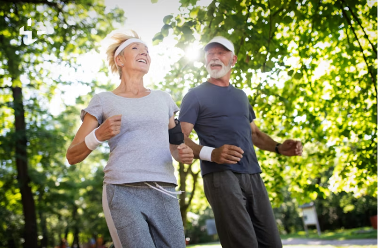 공원에서 함께 조깅하며 웃고 있는 노년의 남성과 여성. 운동복을 입고 건강한 라이프스타일을 실천하는 모습. 밝은 햇살과 푸른 나무들이 어우러진 배경.