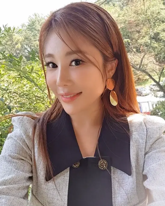 현역가왕- 긴 생머리를 늘어뜨리고 흰색정장에 금색 귀거리을 하고 머리를왼쪽으로 살짝튼채 화면을 보며 셀카를 찍는 김소유