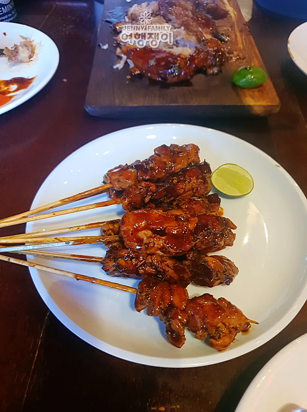 발리 스미냑 너티 누리스 돼지고기 사테 꼬치, 라임 곁들임 — Naughty Nuri’s Seminyak pork belly satay skewers with lime.