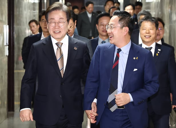 대선에 출마하는 이재명 더불어민주당 전 대표가 16일 오후 서울 여의도 국회에서 열린 비공개 의원총회에 참석하며 박성준 원내수석부대표와 손을 잡고 참석하고 있다./뉴스1