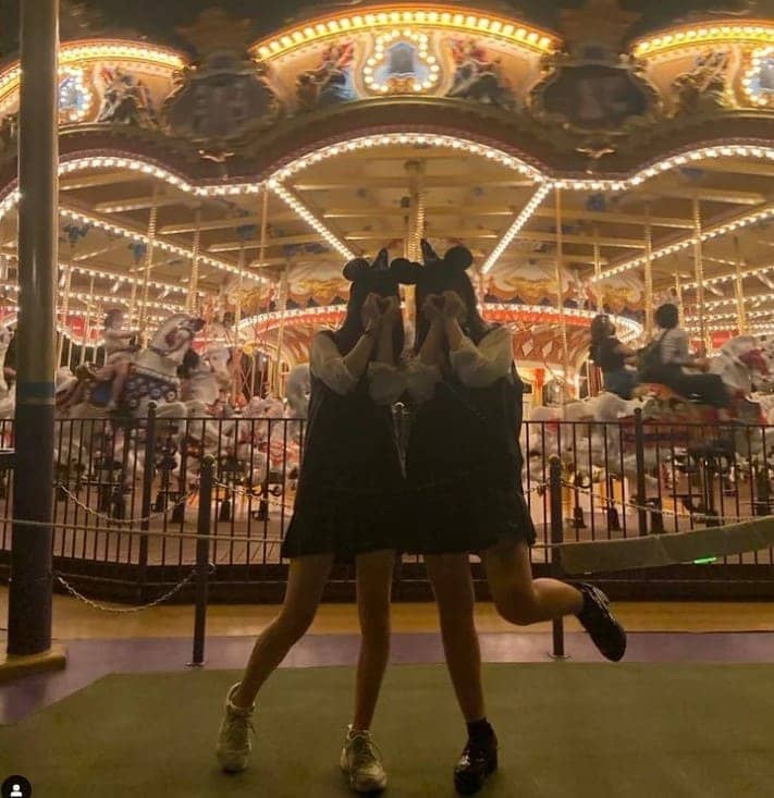 회전 목마 앞에 두 여성이 서있다.