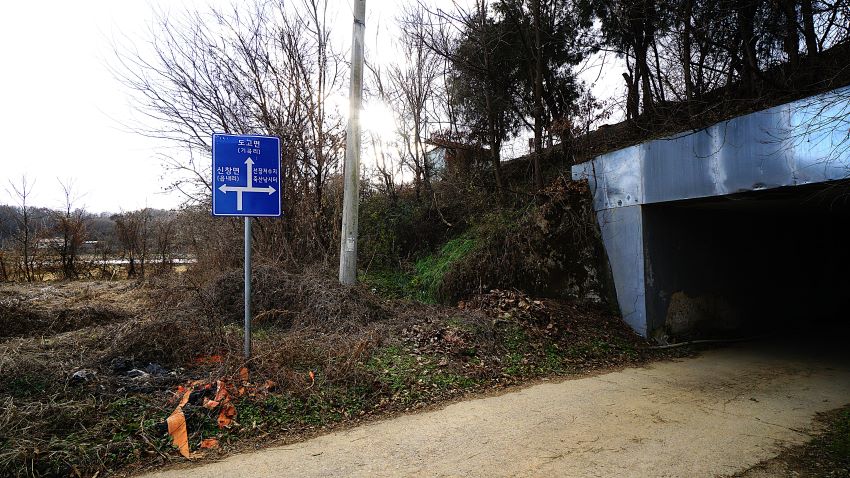 파란 판에 흰 화살표 표시된 이정표, 우측 굴다리,