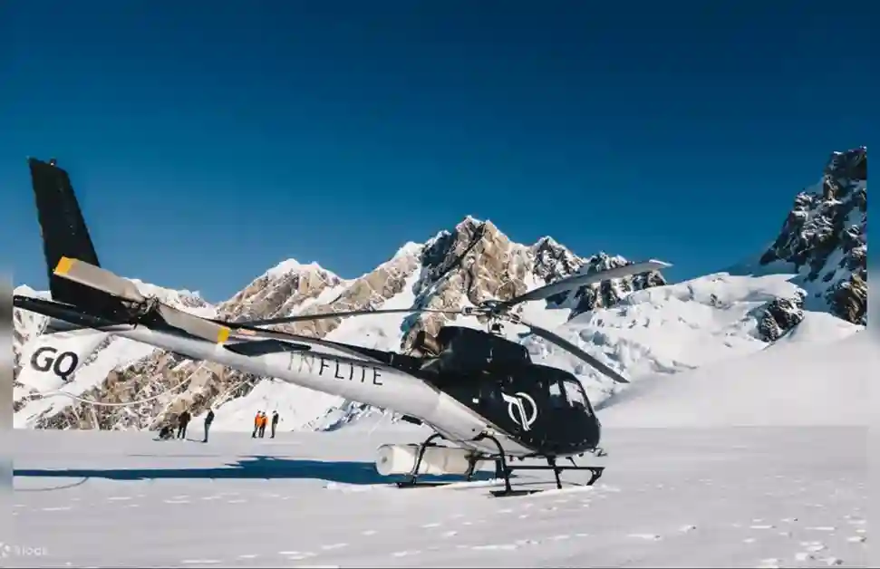 뉴질랜드 마운트 쿡 헬기 투어 중 설원에 착륙한 헬기와 뒤로 보이는 아름다운 설산 풍경