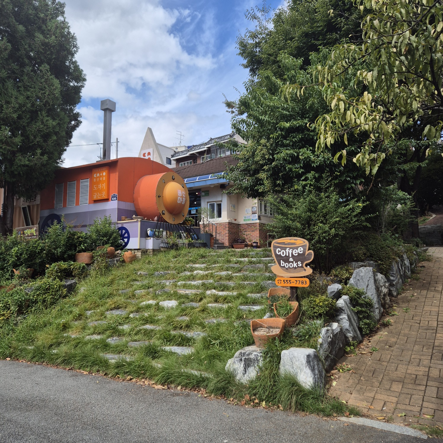 초록색 아름드리 나무를 사이로-주황색으로 예쁘게 색칠된 기차모형