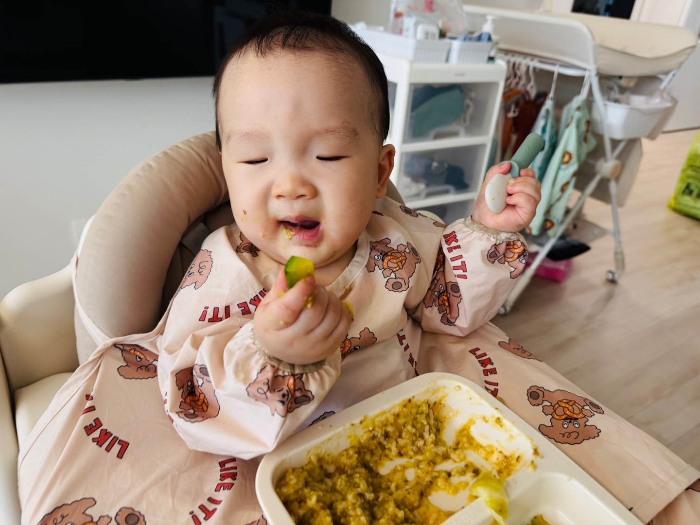 애호박 스틱을 손에 들고 인상을 찡그리며 먹는 찬솔이의 점심 식사 장면