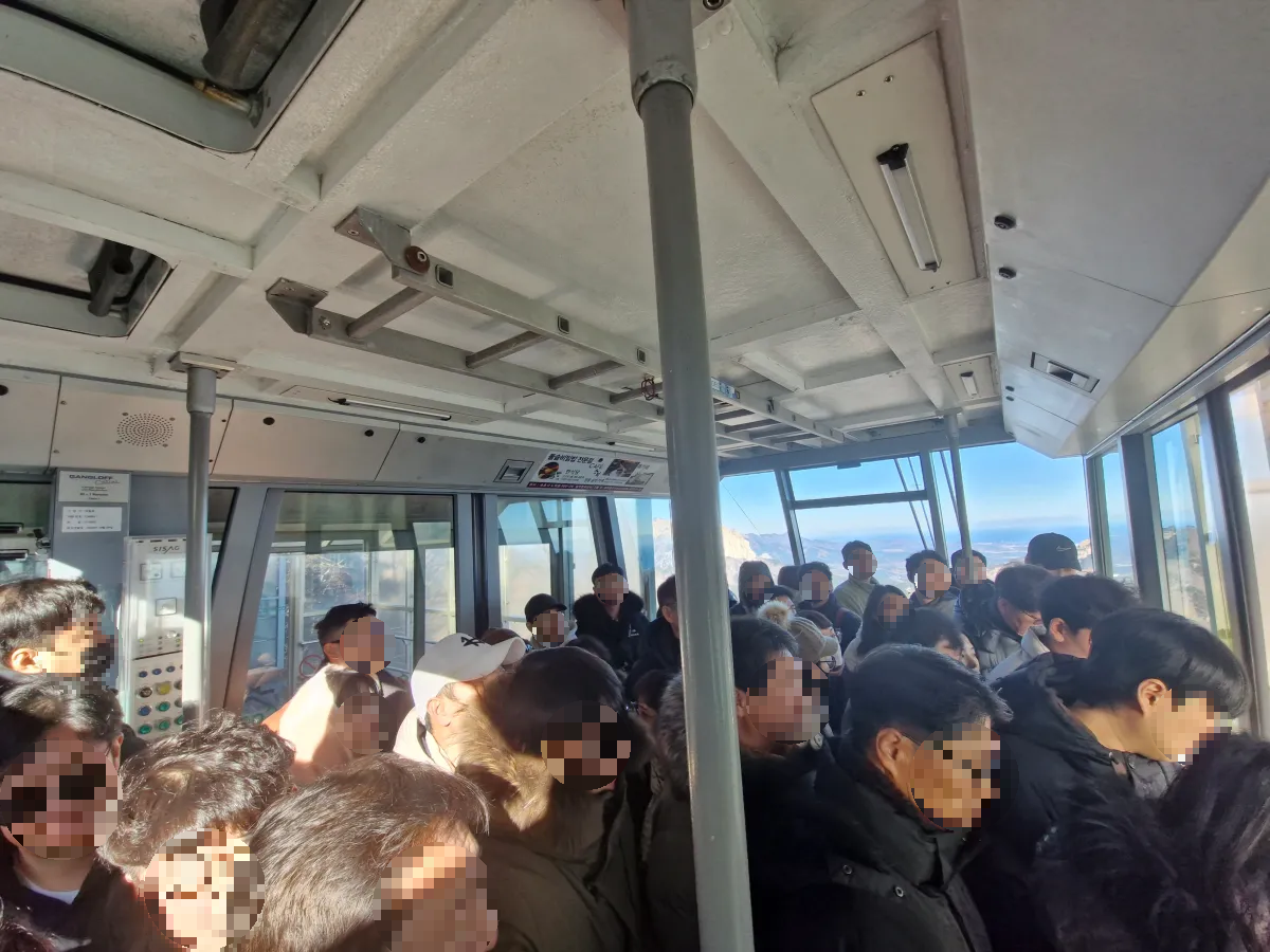 케이블카-안에-사람들이-많이-탑승해-있다