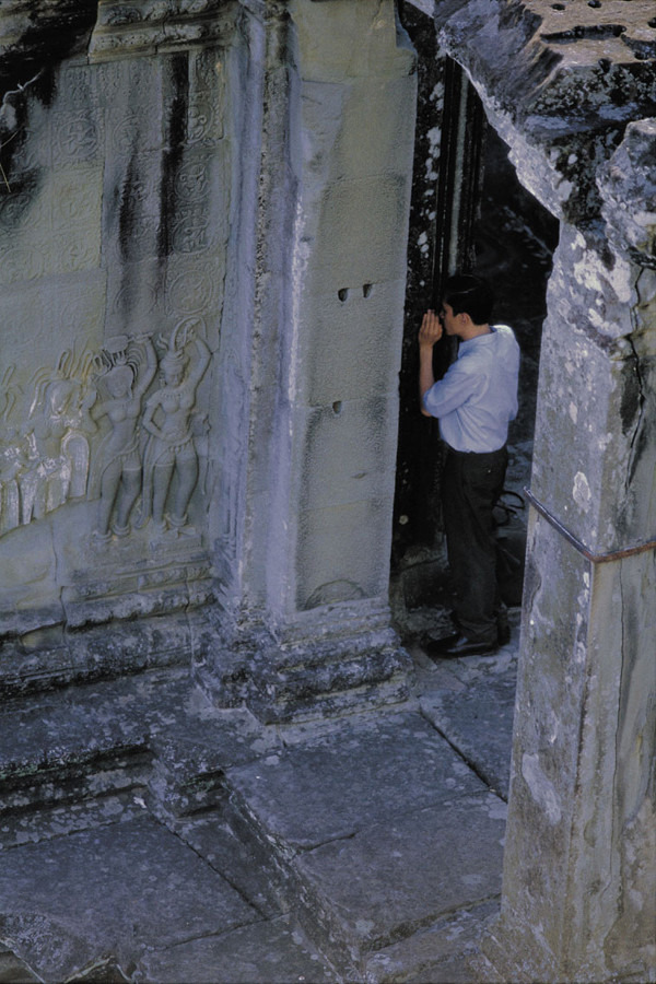 영화 화양연화 중 앙코르와트 사원의 비밀스러운 구멍에 속삭이는 차우의 모습