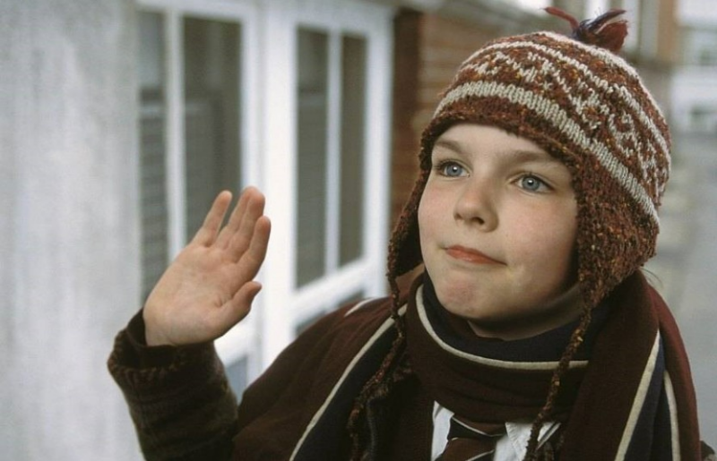 마커스가 모자를 쓰고 오른 손을 흔드는 모습