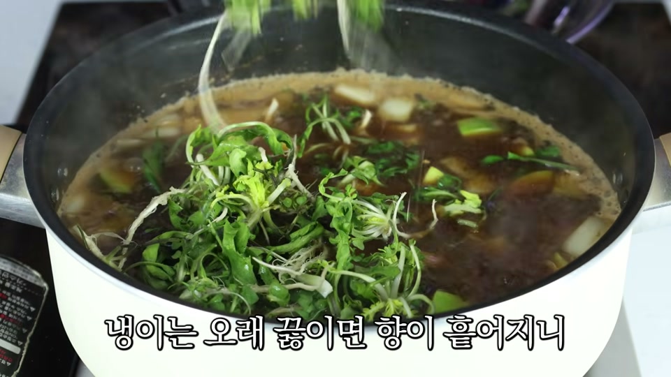 끓는 육수에 냉이를 넣는 장면