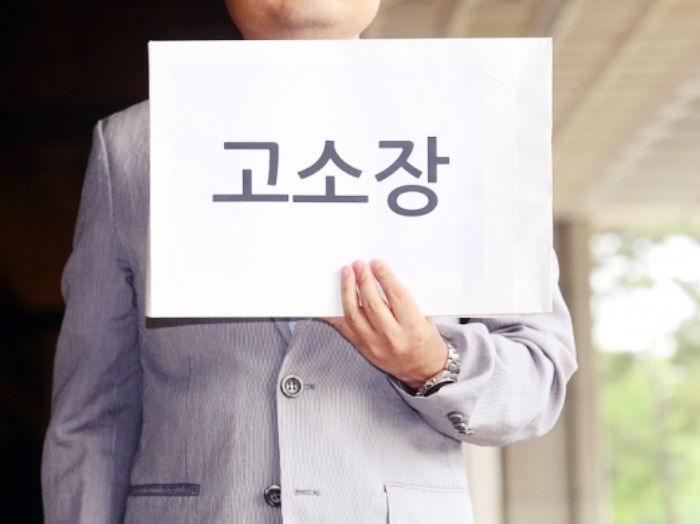 고소장을 들고 있는 사진