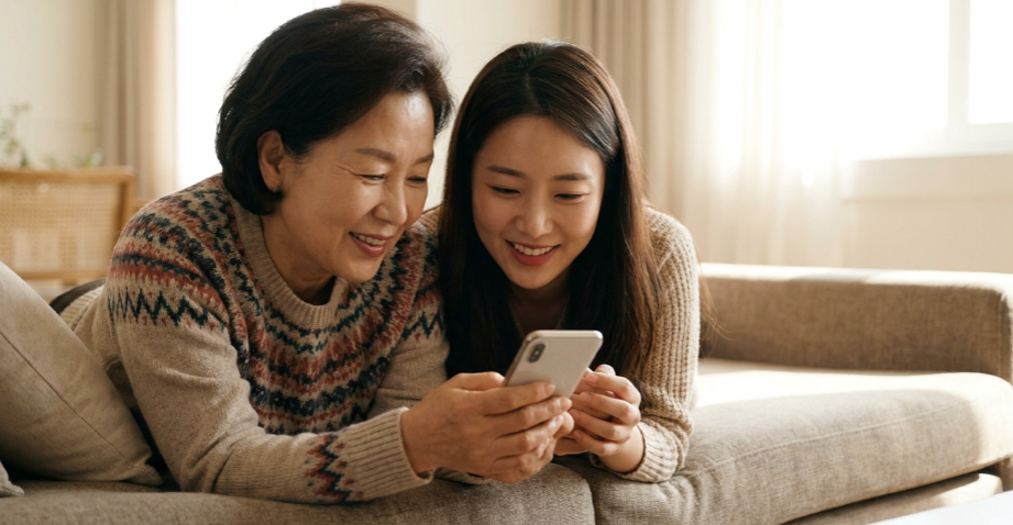 다정하게 스마트폰을 함께 보며 대화하는 모녀
