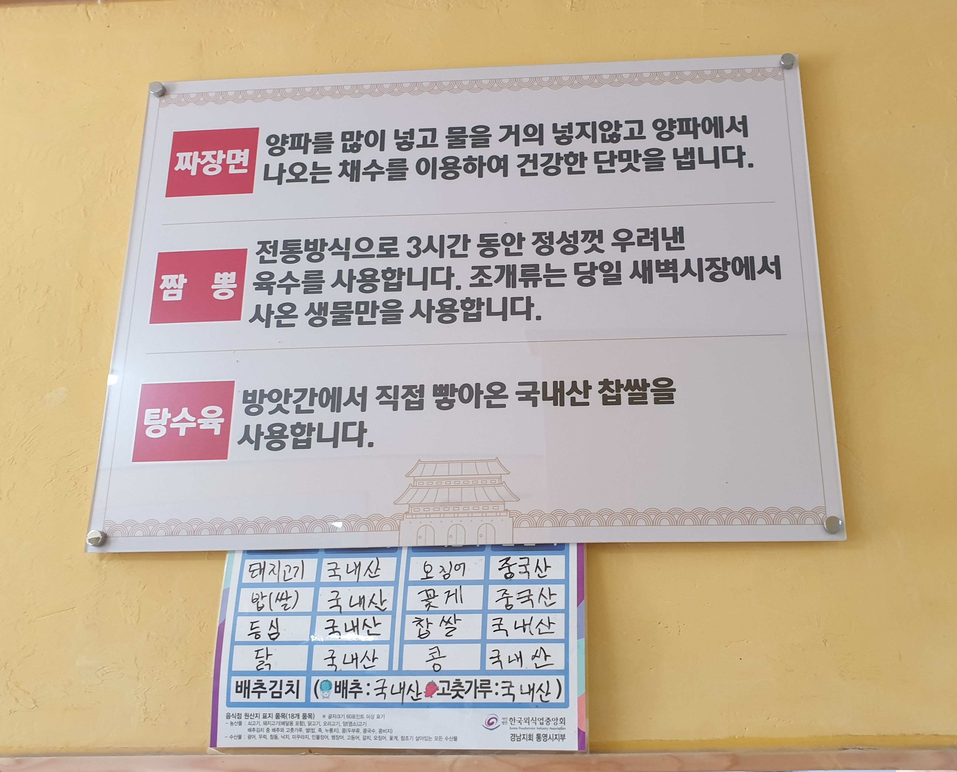 벽에 걸린 흰 표지에 있는 메뉴의 원산지표시