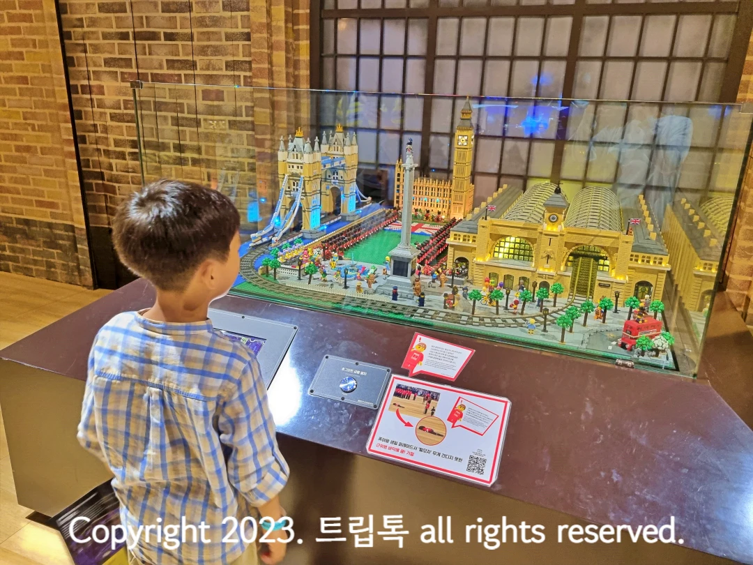 베이지색 기차역과 갈색 기찻길과 건물을과 파란 다리가 브릭으로 만들어졌다