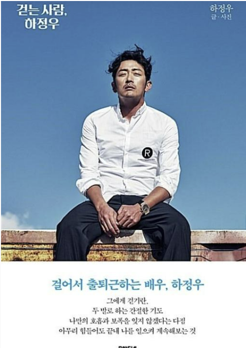 "배우 하정우의 에세이 책 표지 '걷는 사람, 하정우'. 하얀 셔츠를 입고 청바지를 착용한 하정우가 푸른 하늘 아래 앉아 있는 모습. 책 제목과 '걸어서 출퇴근하는 배우, 하정우'라는 문구가 적혀 있다."