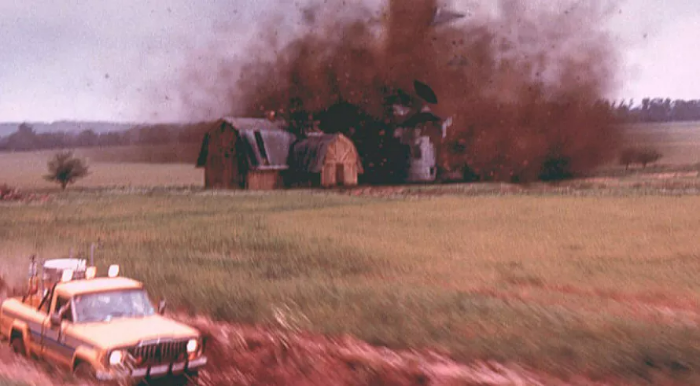 들판에서 토네이도에 의해 파괴되는 집