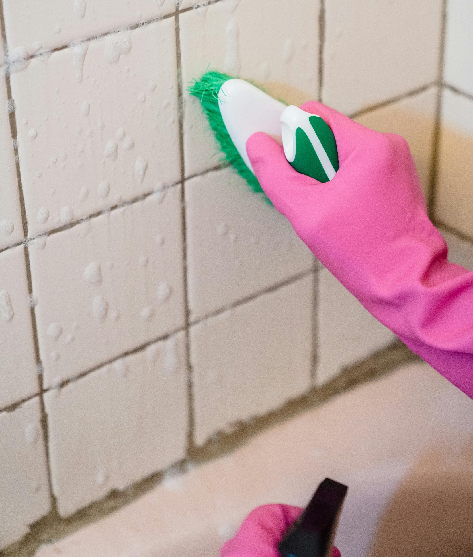 타일 틈을 솔로 청소하는 모습