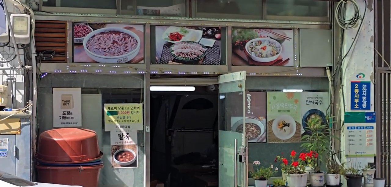 식당 앞 모습이에요. 간판 위에 대표 메뉴 사진이 걸려 있어요.