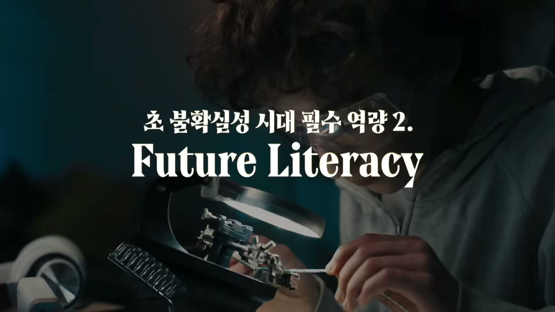 시계공이 작은 부품을 조립하는 자료영상에 흰 글씨로 '초 불확실성 시대 필수 역량 2. Future Literacy' 오버레이