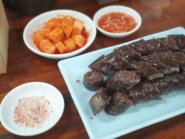 테이블 위에 순대, 깍두이, 새우젓, 소금이 놓여있다.