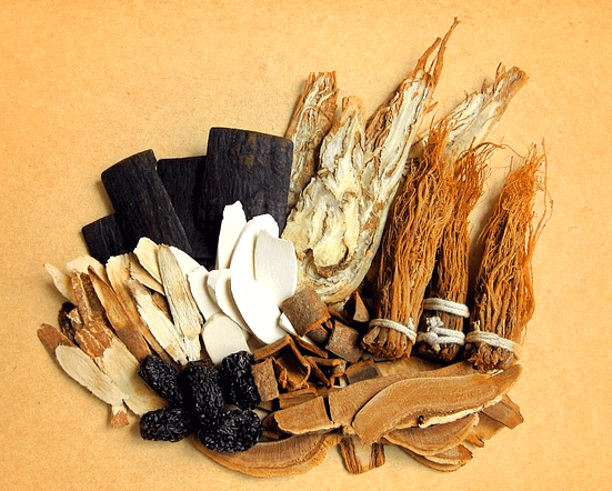 노란 바탕화면에 한약재들이 한가득 모여있다. 검정색의 약재, 슬라이스로 썰어진 나무약재들, 나무뿌리 한약재들이 가득하다.