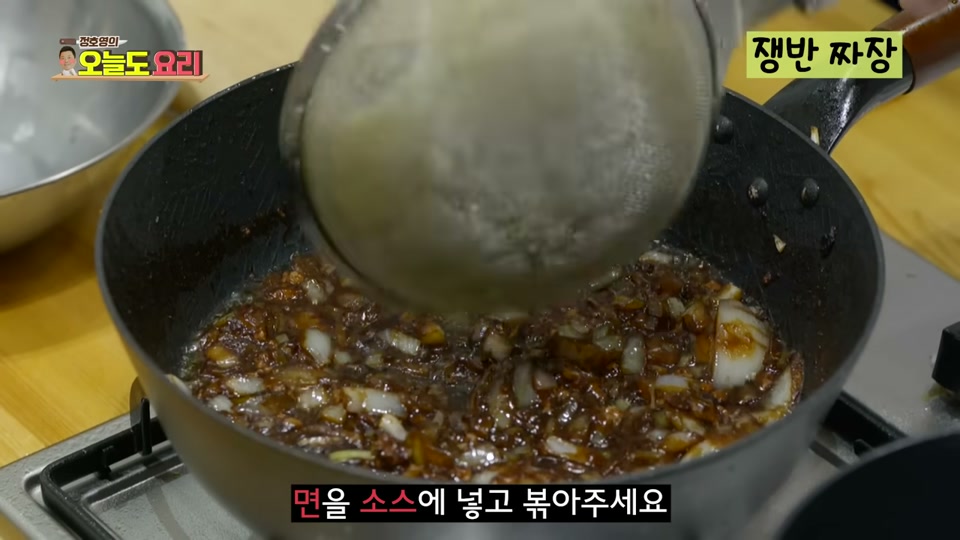 면을 짜장 소스에 넣고 볶는 모습