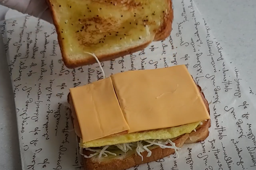 식빵에 소스를 바르고 준비한 재료는 넣는 모습