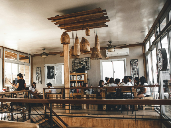 목재 인테리어로 감각적인 카페. 손님들이 앉아 이야기를 나누고 있다.