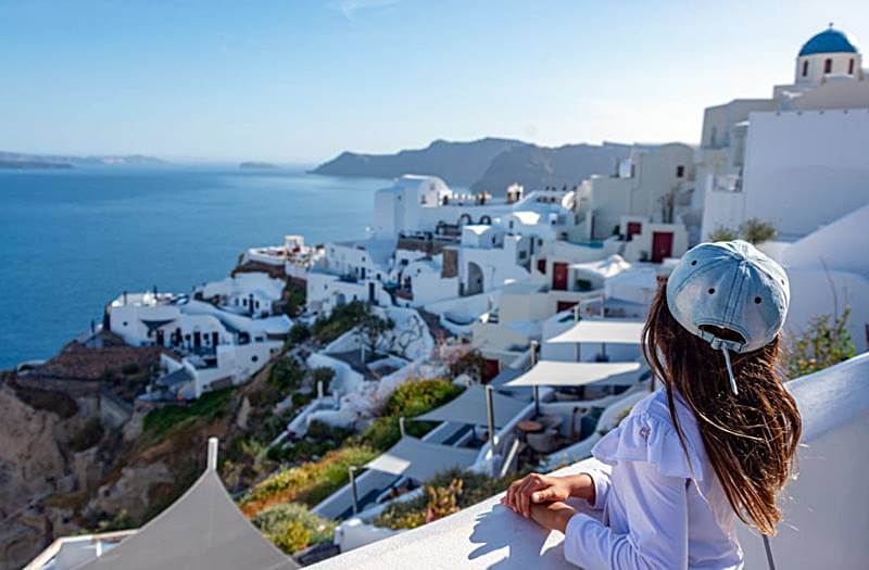 파란-바다와-하얀-건물을-바라보는-여성의-뒷모습