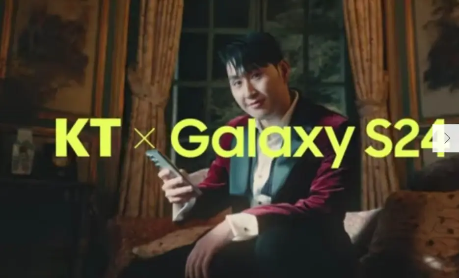 이강인-
황금색 커튼이 쳐든 실내 황금색 의자에 앉아 붉은 벨벳 쟈켓을 입고 오른손으로 핸드폰을 든채 미소짓고 정면을 바라보는 모습 위 노란글씨 KT X Galaxy S24