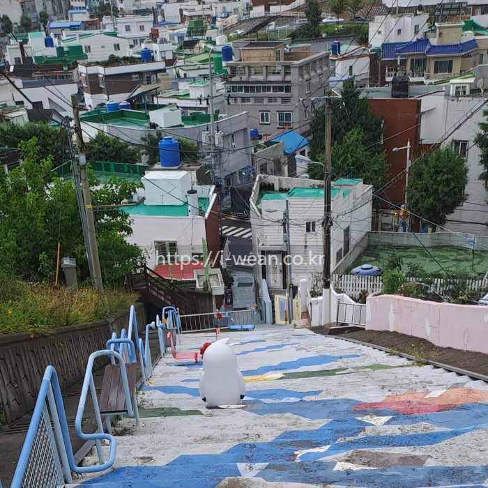 계단에 동백이 조형물이 놓여 있습니다.