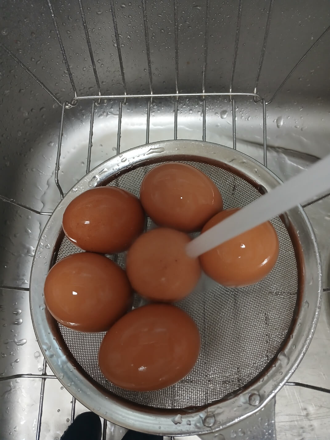 채망에 건진 계란을 흐르는 물에 식힙니다.