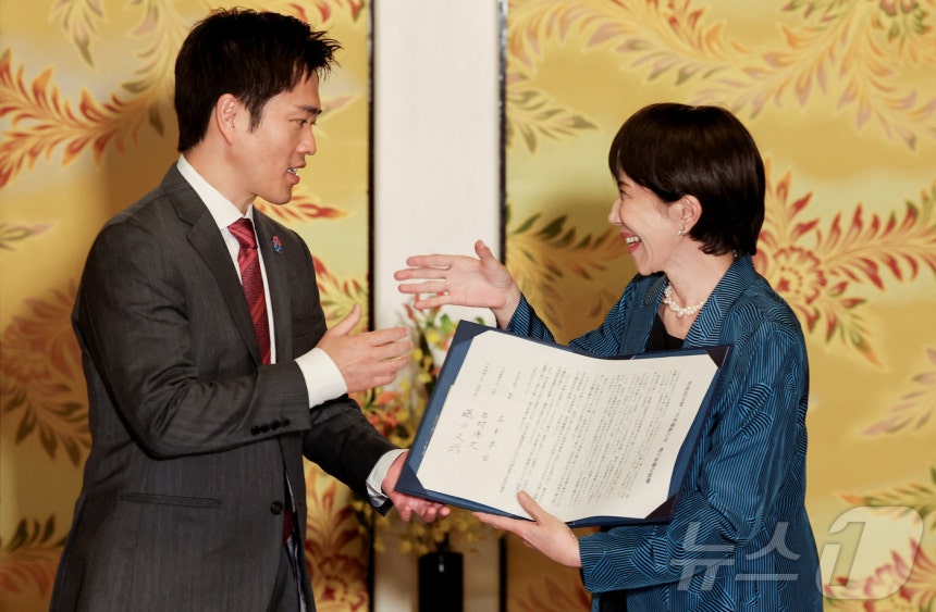 요시무라 히로후미 일본유신회 대표(왼쪽)와 다카이치 사나에 자민당 총재가 20일 연정 구성 합의를 체결한 후 악수를 나누고 있다.