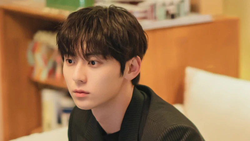 어느 실내를 배경으로 검은 자켓을 입고 소파에 앉아 있는 김도하