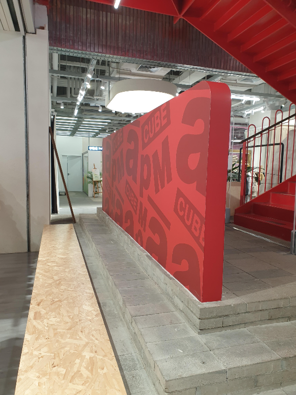 apM 존, 붉은색 apM 간판이 게단 입구에 놓여있다.