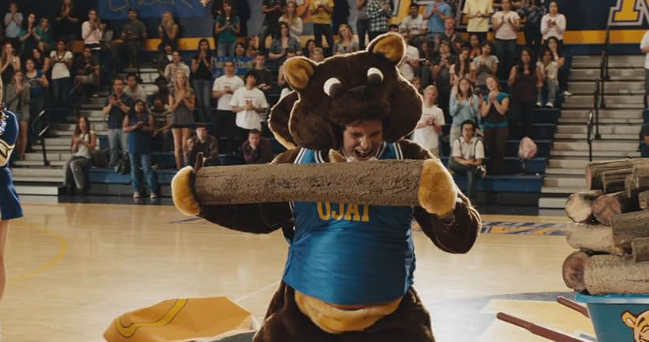 학교 마스코트 복장을 입고 열심히 응원 중인 장면. 이 영화 속 인물들의 엉뚱하고 유쾌한 분위기를 보인다