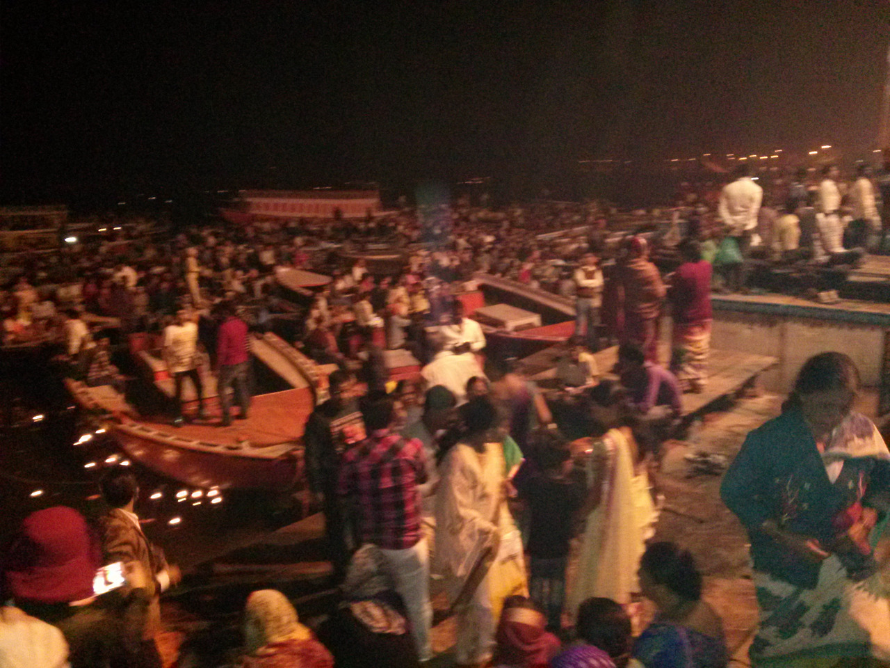 "밤의 갠지스강 가트에 수많은 보트와 인파가 빼곡하게 모여 아르띠 뿌자 의식을 기다리는 인도 바라나시의 역동적인 야경"