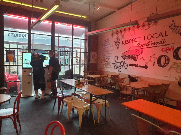 벽면에 그라피티가 그려져있는 매장 내부. 테이블을 우드 의자는 철제로 되어 있다.