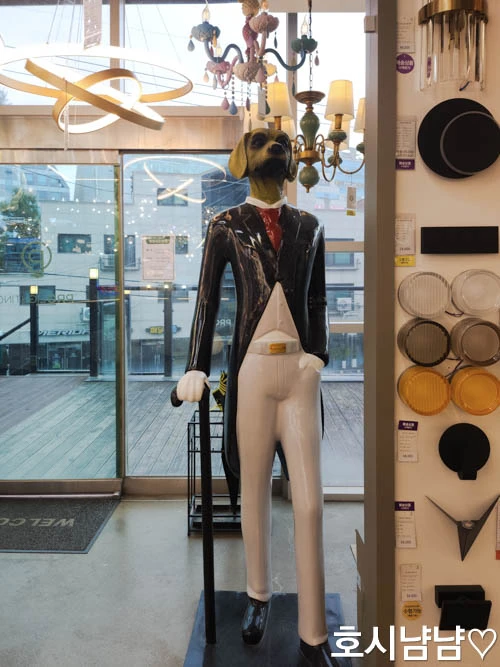 프로라이팅 하남점 입구의 양복 입은 강아지 조형물과 인테리어 조명 전시