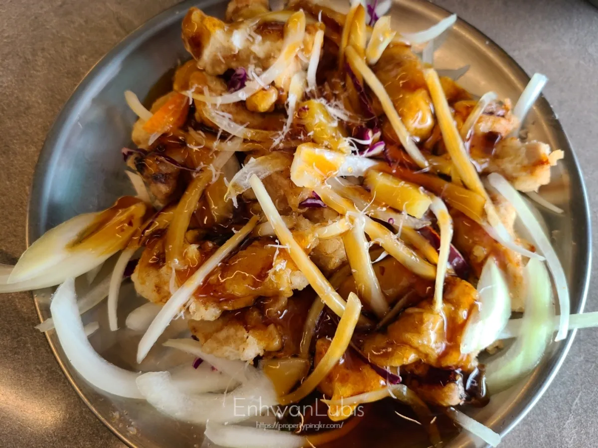 스텐-접시에-담긴-갈색-소스가-뿌려진-채썬 -양파와-튀여진-거동탕수육