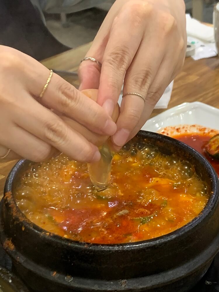 조개 순두부찌개에 계란 넣는 모습