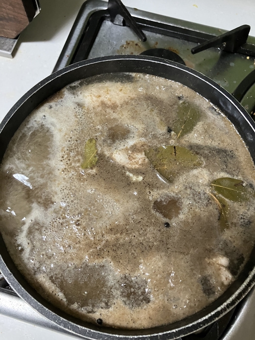 닭가슴살이 육수에 잠긴 채 약불로 조리되는 중&amp;#44; 월계수잎과 후추가 떠 있는 상태