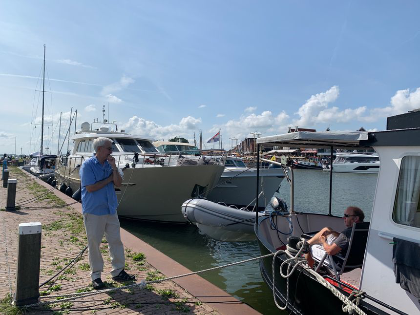 볼렌담에서 커다란 세일 보트로 여행중인 부부와 대화하는 남편 모습