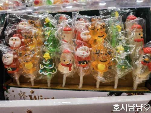 상자 속에 진열된 윈터 스윗 캔디 팝스 막대사탕. 산타, 루돌프, 눈사람, 트리 모양이 보인다.