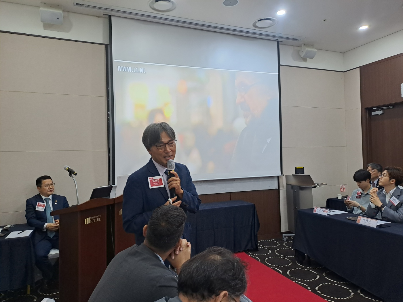 정우 음향전문 이원상대표님이 주간회의중 제일 앞에나와 자신의 30년 음향사업이야기를 발표하고 있습니다. 다른 멤버들은 이원상대표님의 이야기를 경청하고 자리에 앉아있습니다.