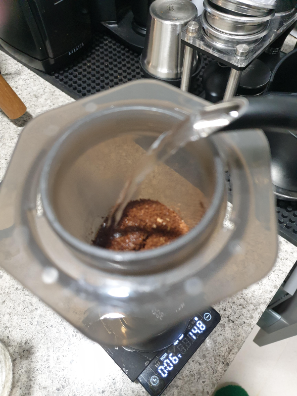 원두가 담긴 에어로프레스에 물을 넣고 있다.