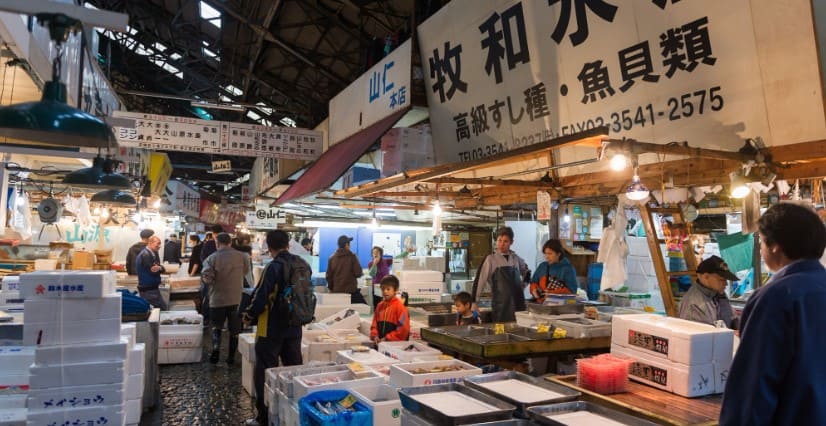 시장에 흰 박스와 여러 사람들이 서 있다