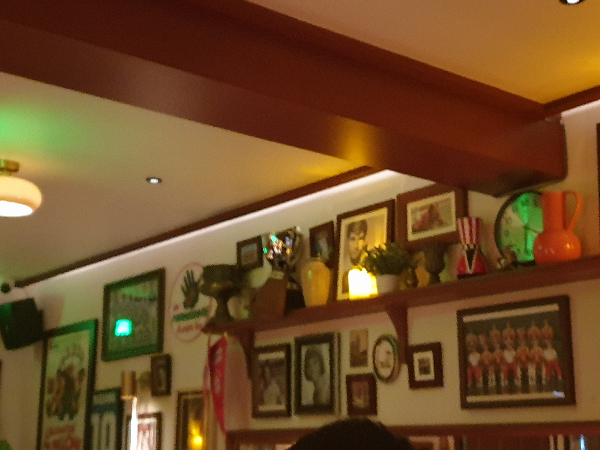 천장에 나무 보가 길게 있고 벽면에는 액자와 트로피들이 보인다.