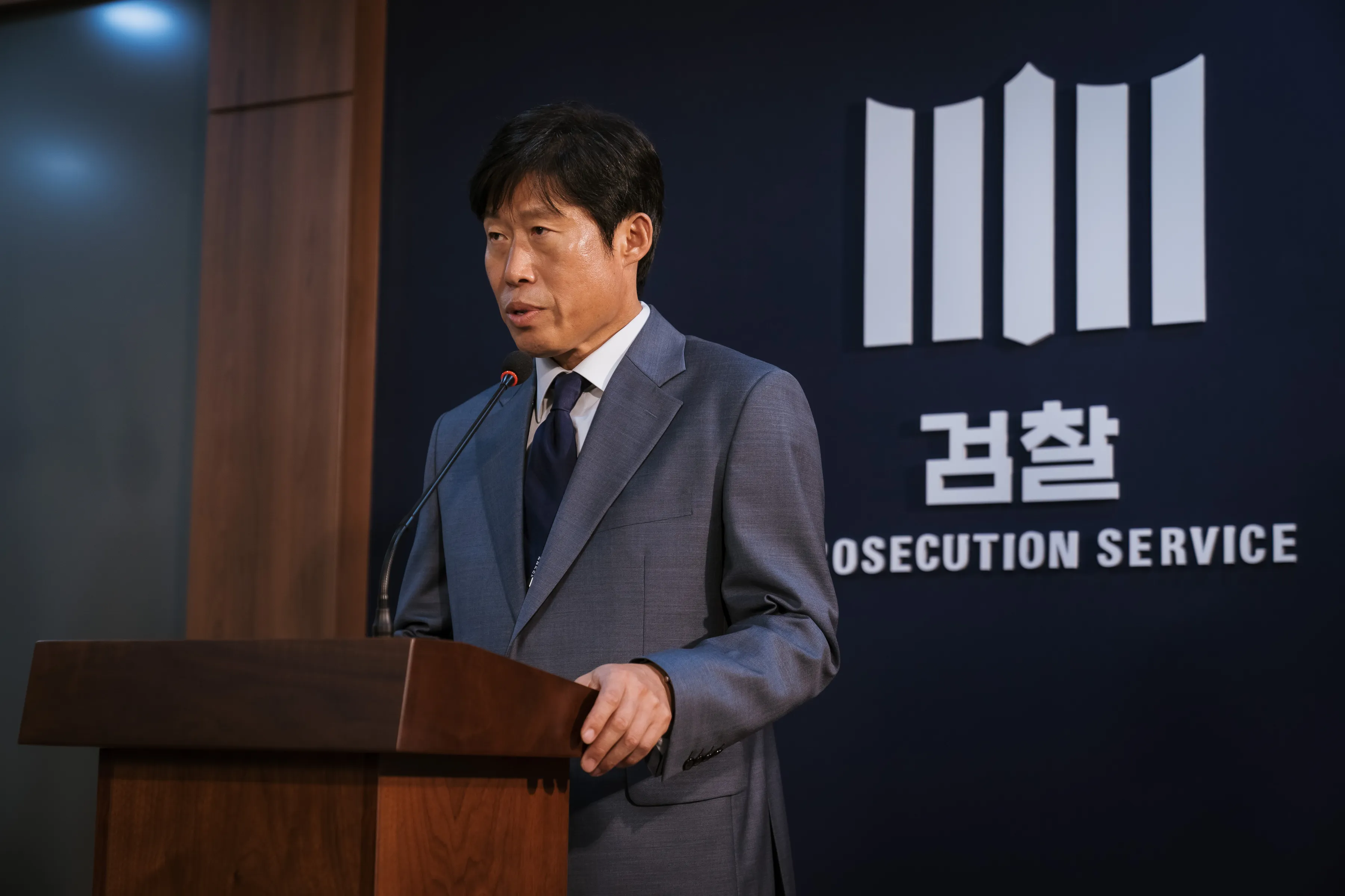 유해진이 검사역으로 언론 브리핑을 하고 있다.