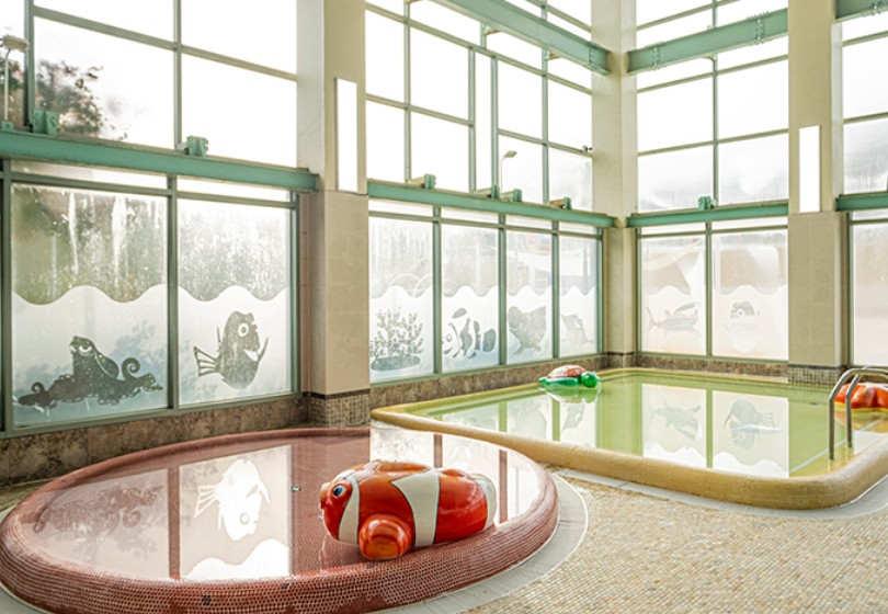 테르메덴 실내 유아 풀, 낮은 수심과 귀여운 물고기 튜브가 배치된 어린이 전용 온천 공간
