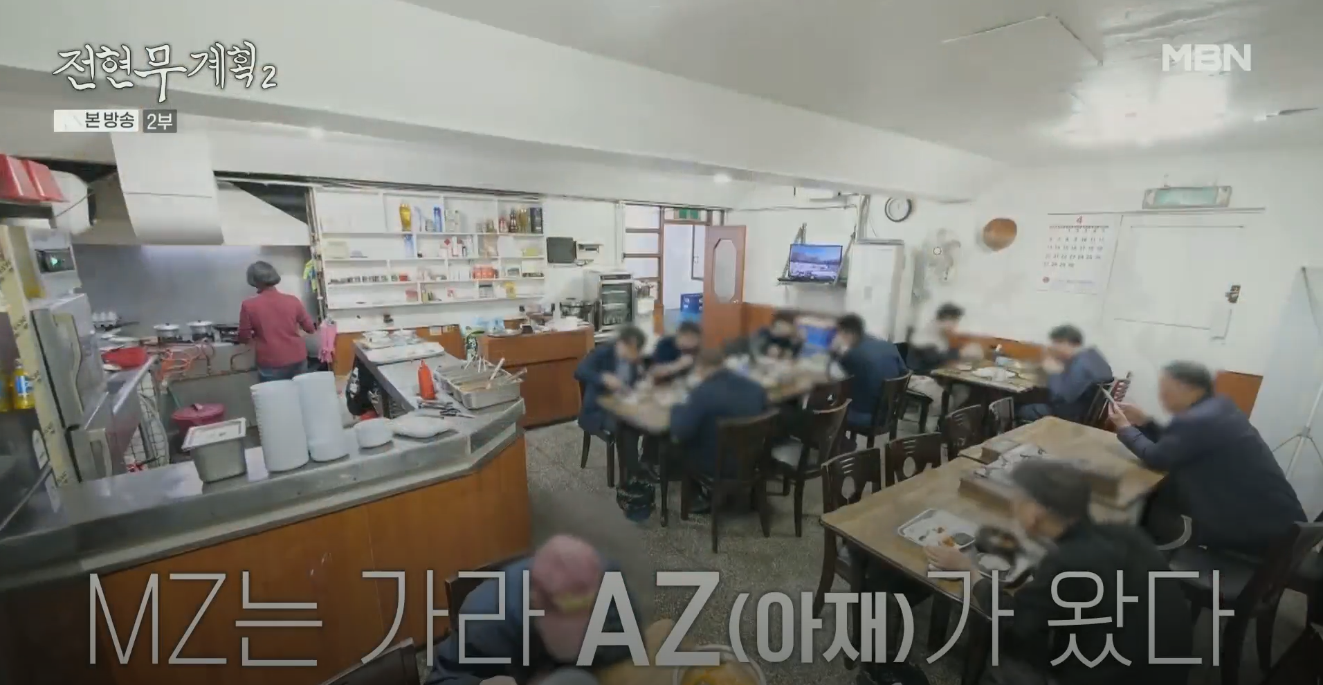 오픈 주방에서 밥을 짓고 있는 모습이 보이는 식당 실내 분위기